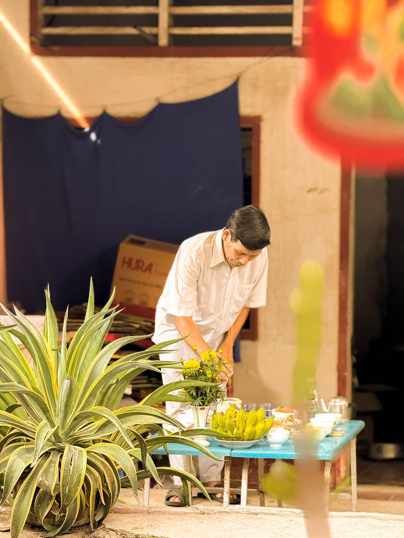 A man placing incense among the offerings on the table